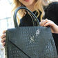 The Beaux-Arts bag charms with its unique round shape and elegant design in black croco