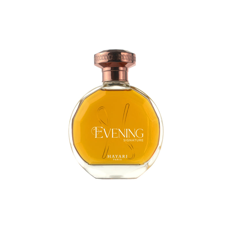 Evening perfume in a round clear bottle with a copper-colored cap on a white background