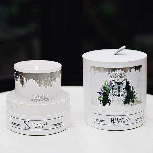 secret mystique scented candle in white cylindrical packaging with a wolf in the forest